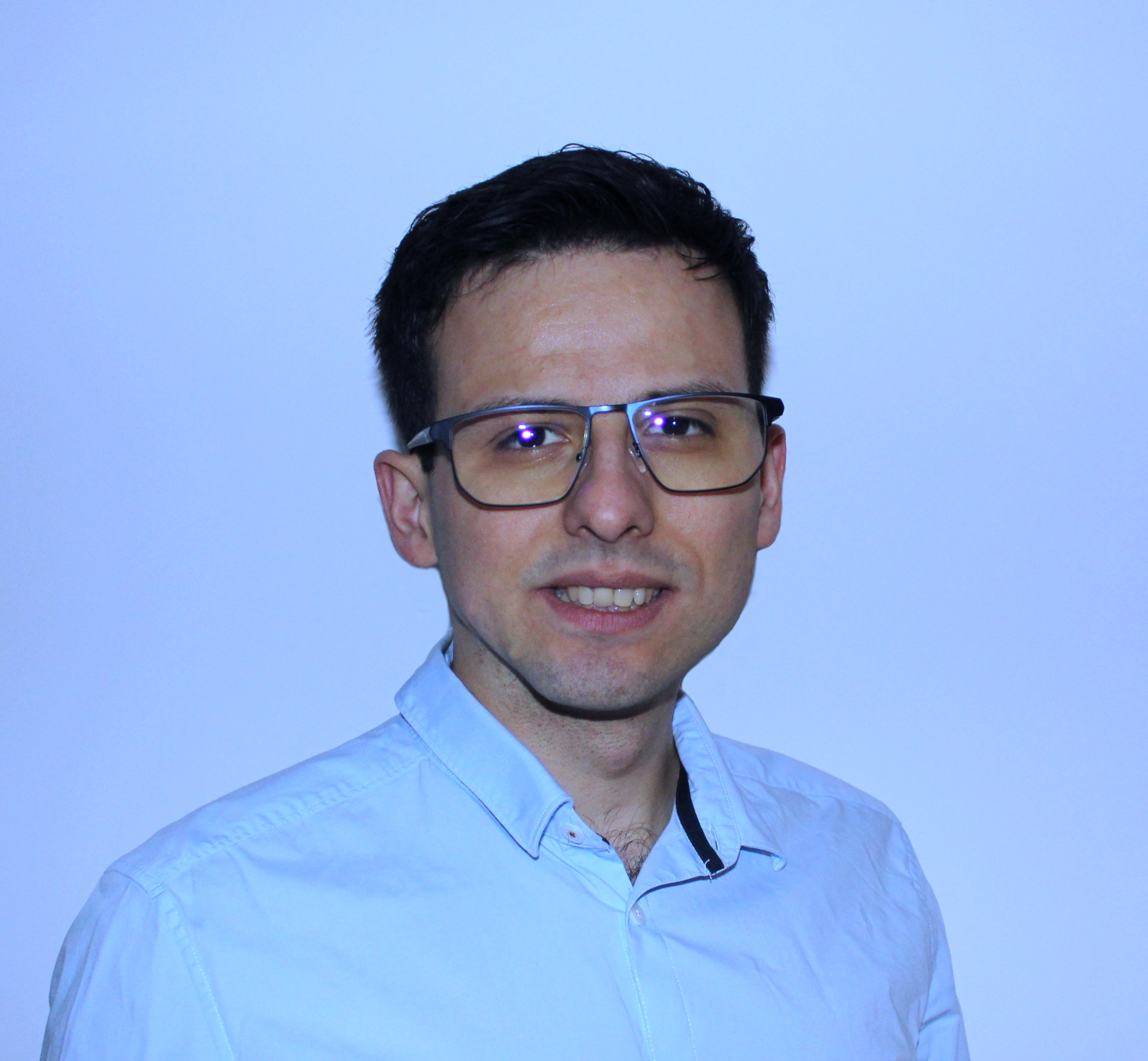 Portrait de Yann Picot, avec un effet lumière bleu en fond.